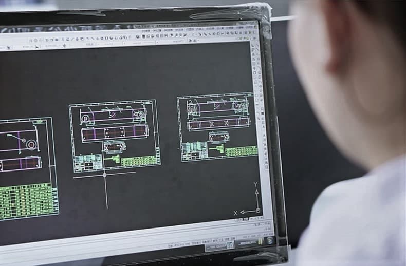 Engineer reviewing hoist drawings at the Grues Treuil design centre